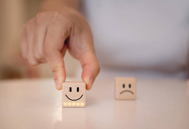 istock Hand choose emoticon smiley face on wood cube. Customer service, review, feedback and rating concept. 1496800802