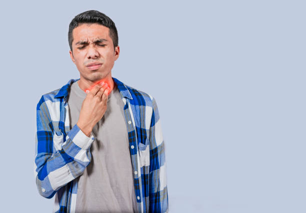 istock Young man with throat problems, Man with tonsils problems in an isolated infection concept 1496803836