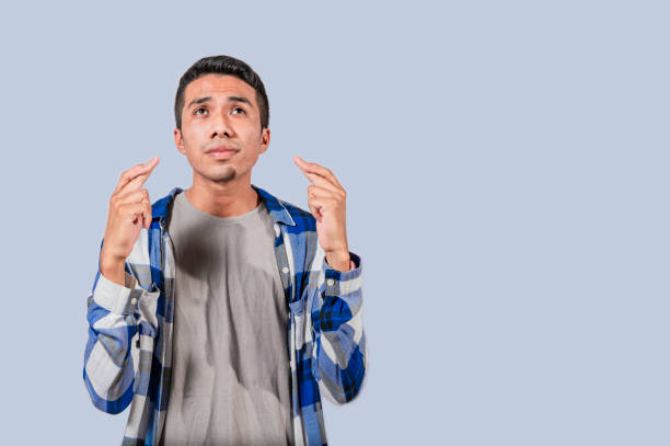 istock Positive people smiling making a wish while crossing his fingers. Man making a wish crossing his fingers, Concept of positive person making a wish and crossing his fingers isolated 1496803872