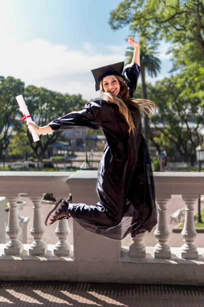istock Girl recently graduated with her degree in her hand, jumping 1496807333