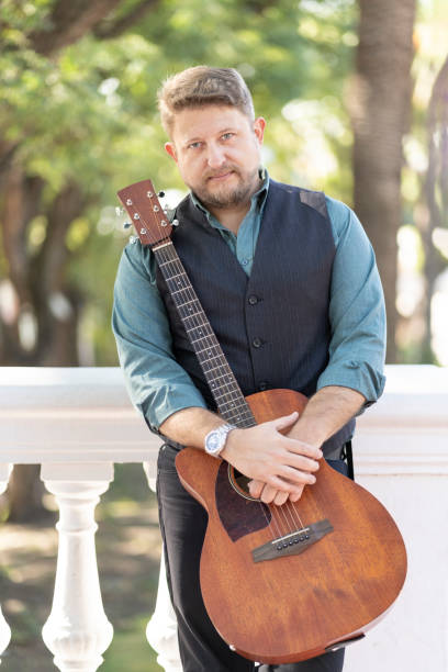 istock Guitarist posing standing in a park with his guitar 1496807344