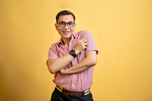 Man with eyeglasses and a shirt standing on a colored background