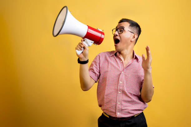 istock Man with eyeglasses and a shirt talking on a megaphone 1496808011