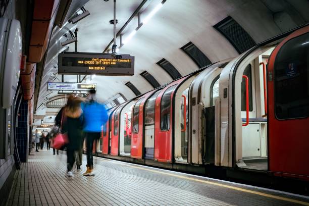 istock Long passenger train at a railway platform, with commuters walking by and along the tracks 1496809390