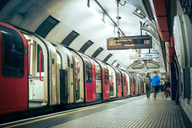 istock Long passenger train at a railway platform, with commuters walking by and along the tracks 1496809399