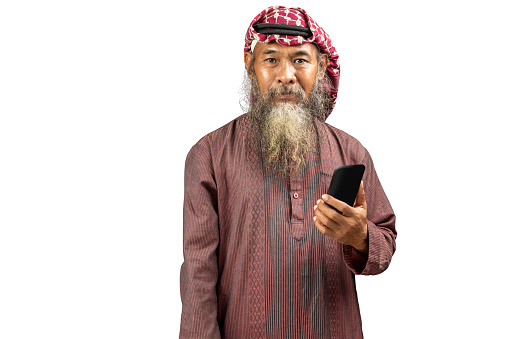 Muslim man with a beard wearing keffiyeh with agal using mobile phone isolated over white background