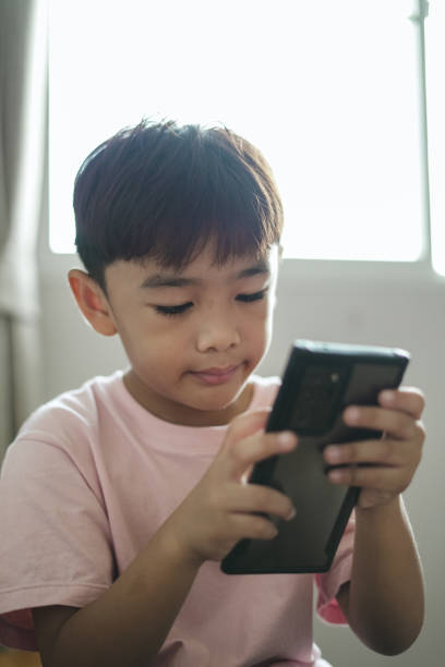 istock Close-up face Boy excited using mobile phone at home 1496811124