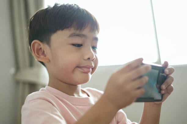 istock Close-up face Boy excited using mobile phone at home 1496811126
