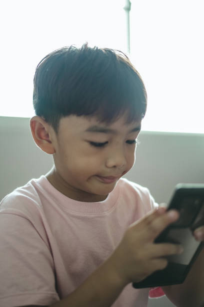 istock Close-up face Boy excited using mobile phone at home 1496811129