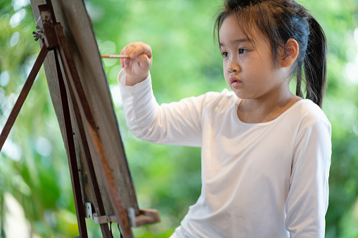 Closeup little asian girl concentrating when paint by water color, Leisure activities when stay at home