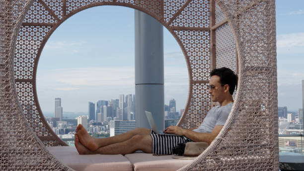 istock Asian male working casually in cabana by the infinity pool in a luxury hotel 1496827128