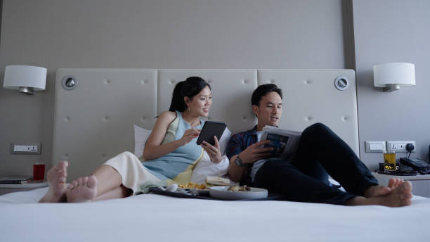 istock Asian couple bonding in hotel room while on holiday trip 1496827231