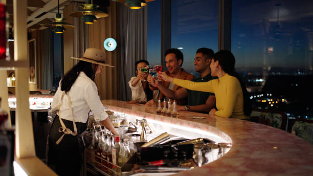 Asian working adults having a drink at hotel bar