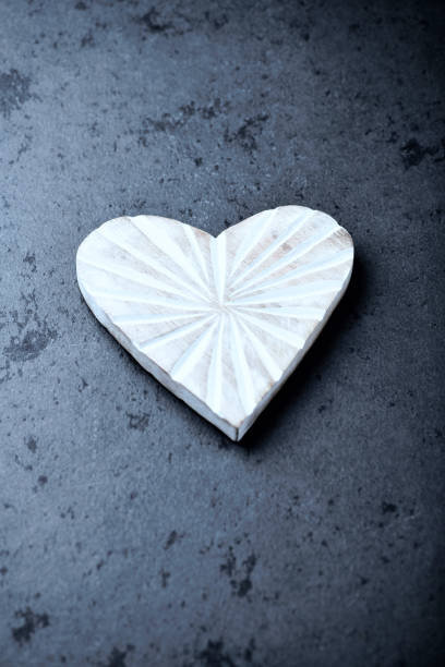 Wooden Heart on dark stone background. Soft focus. Copy space.