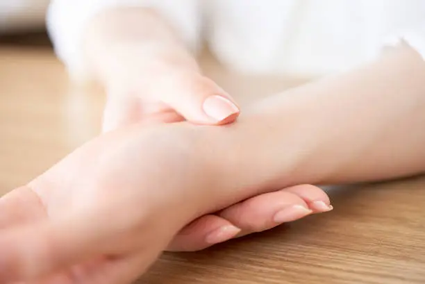 Photo of Woman's hand measuring her pulse