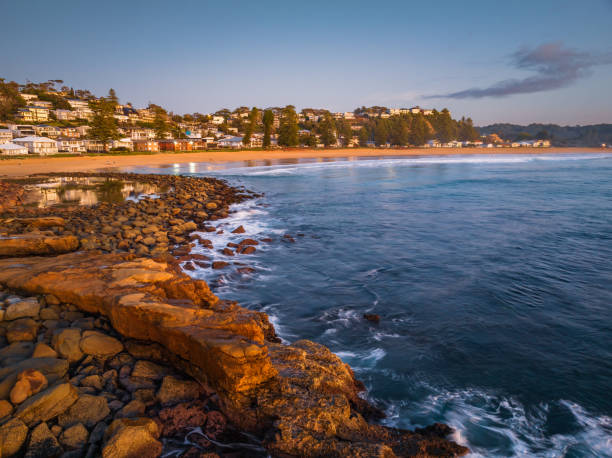 istock Reverse sunrise coastal landscape with rock pool and houses 1496832992
