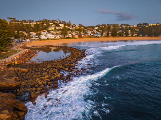 istock Reverse sunrise coastal landscape with rock pool and houses 1496833028