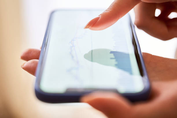 istock A woman's hand checking the exchange chart on her smartphone 1496836090