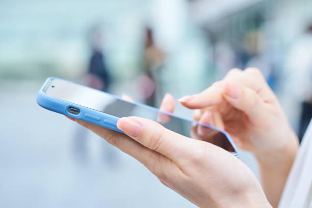 istock a woman using a smartphone on a street corner 1496836313