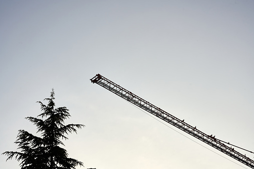 Rising Sun, Maryland USA – May 11, 2022: A lineman from AUI Power being lifted via a tether by a helicopter from HLH Aviation so he can do some maintenance at the top of some high voltage electrical transmission towers at the corner of Biggs Highway and Calvert Rd.