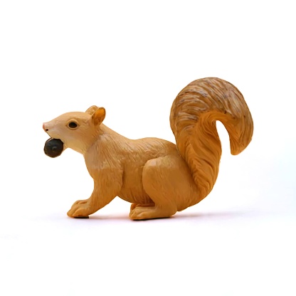 Close-up of miniature toy squirrel animal side view on white background