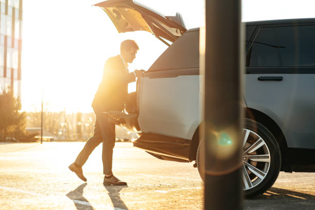istock Successful businessman taking luggage from the car trunk 1496844239