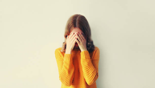 istock Upset sad crying woman covering her eyes with her hands while experiencing mental or physical suffering 1496845424