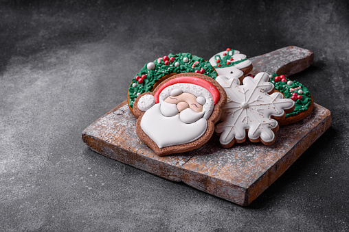 Beautiful colored Christmas gingerbread cookies for the design and decoration of the festive table on a textured concrete background