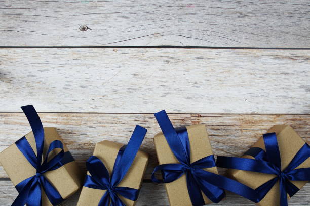 istock Gift boxes with blue ribbon on wooden background 1496849240