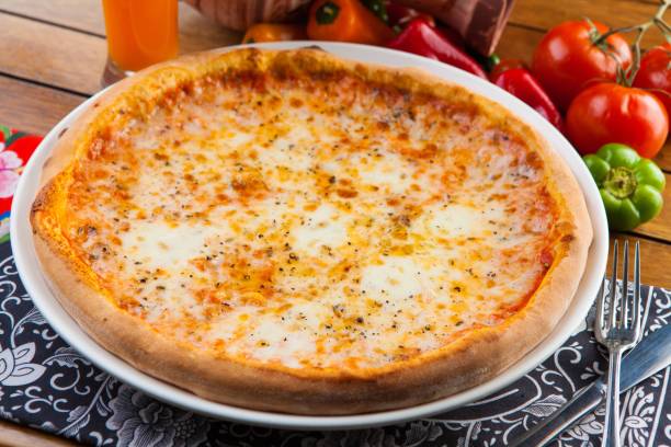 istock Closeup of a delicious fresh cheese pizza on the table 1496849845