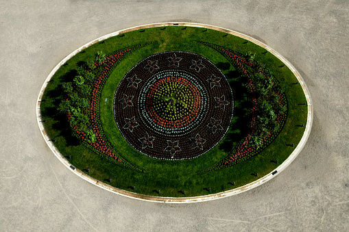 ornamental flowerbed in front of the castle on the ground floor. The planting of annuals is in the shape of a circle with a moon shape. tree roses, stars, c moon, beige threshing sand, broderie, elipse, oval
scoop