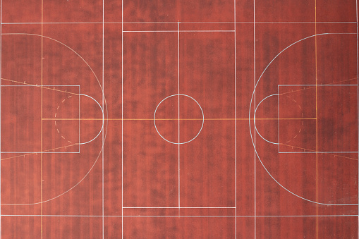 Top down aerial view of a red playing field.