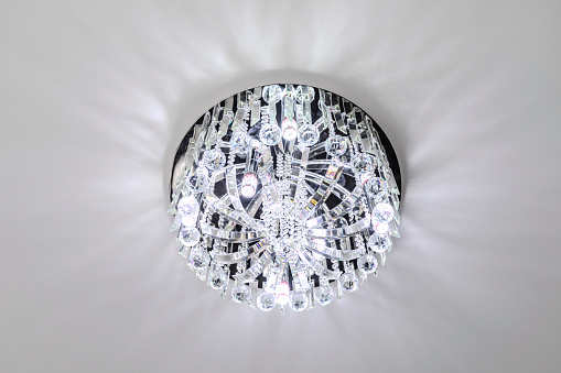 Glass chandelier. Ceiling light source. Lamps shine through a vintage chandelier.