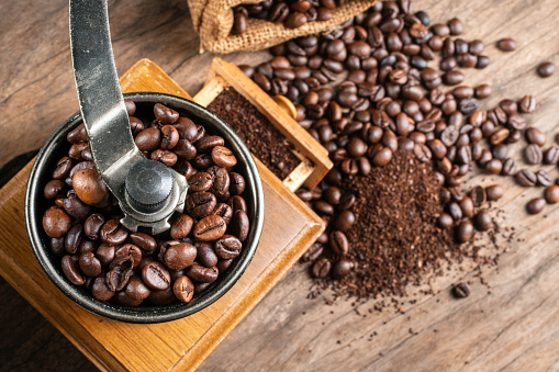 Pile of coffee beans, coffee grinder, ground coffee on a white background. Top view. Banner
