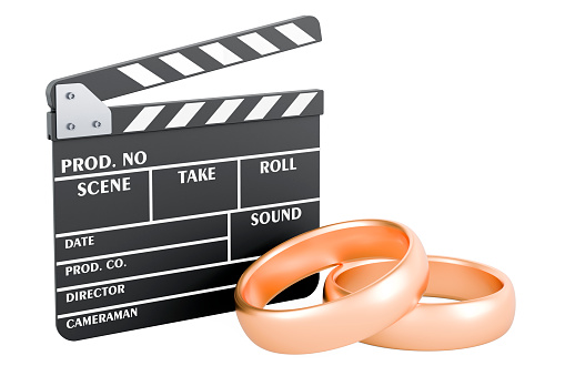 Clapperboard with wedding rings. Wedding videography concept, 3D rendering isolated on white background