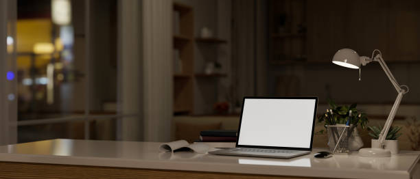 istock A laptop white screen mockup on a table in a modern dark living room at night. 1496860681