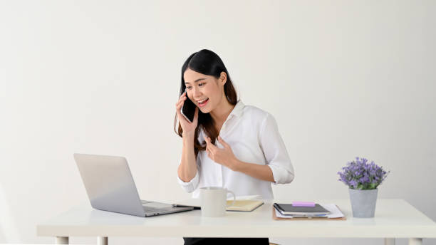 istock A charming Asian businesswoman is talking on the phone with a client while working at her desk. 1496860917