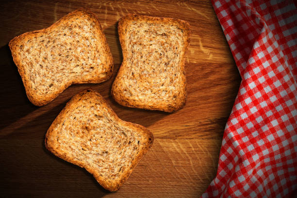 istock Three Rusks on a Wooden Table with a Checkered Tablecloth 1496861414