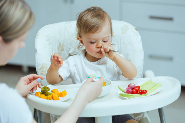 istock Mother teaching baby how to eat by himself. 1496861750