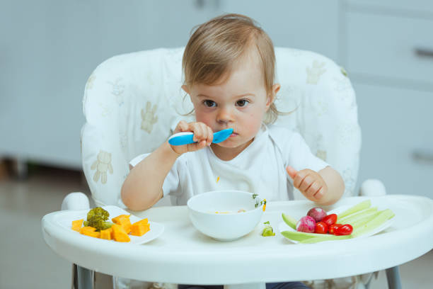 istock Mother teaching baby how to eat by himself. 1496861763