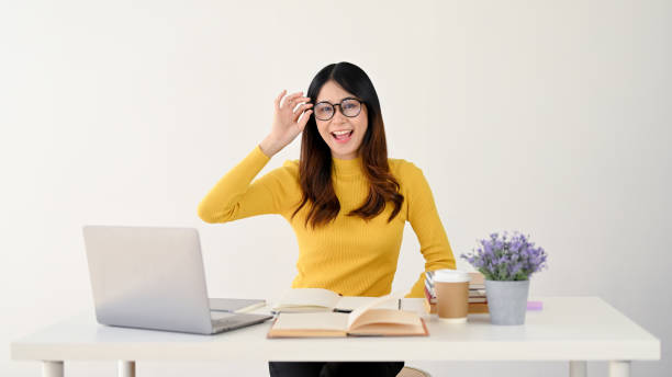 istock A smart Asian female college student is touching her glasses while studying online at her house. 1496862887