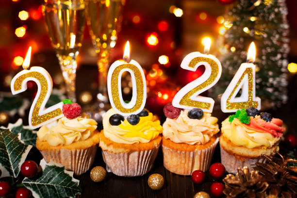 istock Cupcakes with new year candles and wineglasses 1496863578