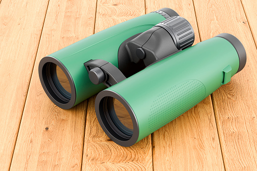 Military binocular on the wooden table, 3D rendering