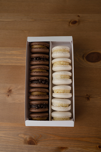 Macaroons in a box on wooden background. Top view.
