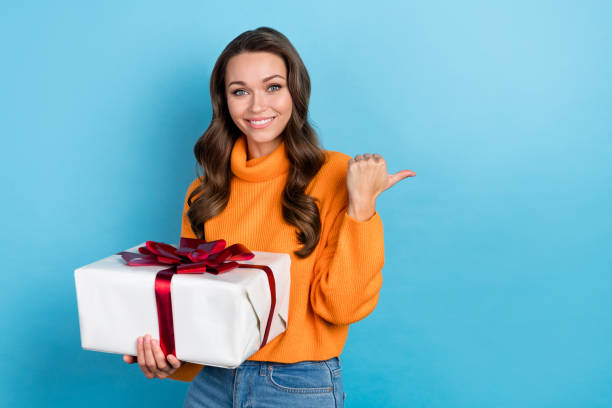istock Photo of cute funny lady wear knitted pullover holding present box thumb empty space isolated blue color background 1496865239