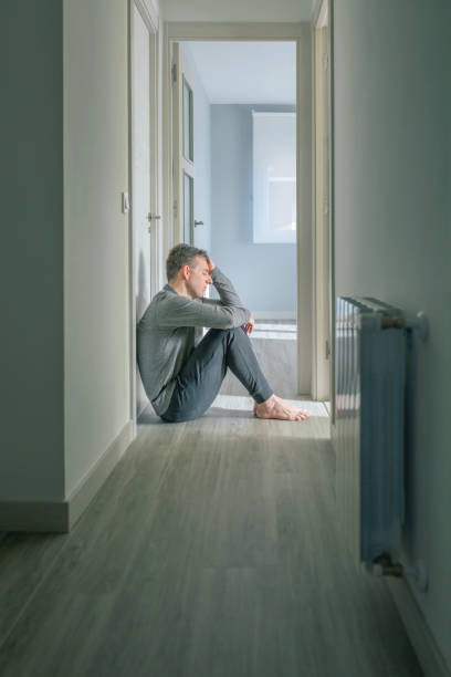 istock Man with mental disorder and suicidal thoughts sitting on the floor 1496867187
