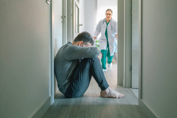 Female doctor running to help patient with mental disorder and suicidal thoughts crying stock photo