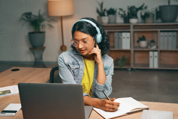 istock Student, laptop or video call for night studying, distance learning and education for college, university or school. Serious, woman or listening to elearning webinar while writing in notebook at home 1496869867