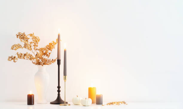 istock beautiful autumn home decor with burning candles in white interior 1496870022