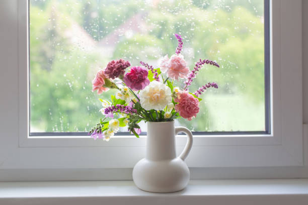 istock pink and purple summer flowers in white jug on windowsill 1496870062